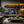 Load image into Gallery viewer, Modern living room with a television displaying colorful abstract art, surrounded by decorative elements.